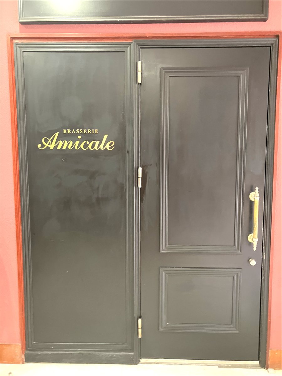 BRASSERIE Amicaleの金文字ロゴが入った黒い扉