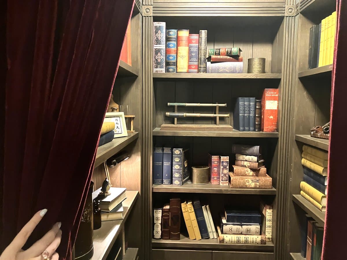 古い洋書や望遠鏡が並ぶ本棚のディスプレイ