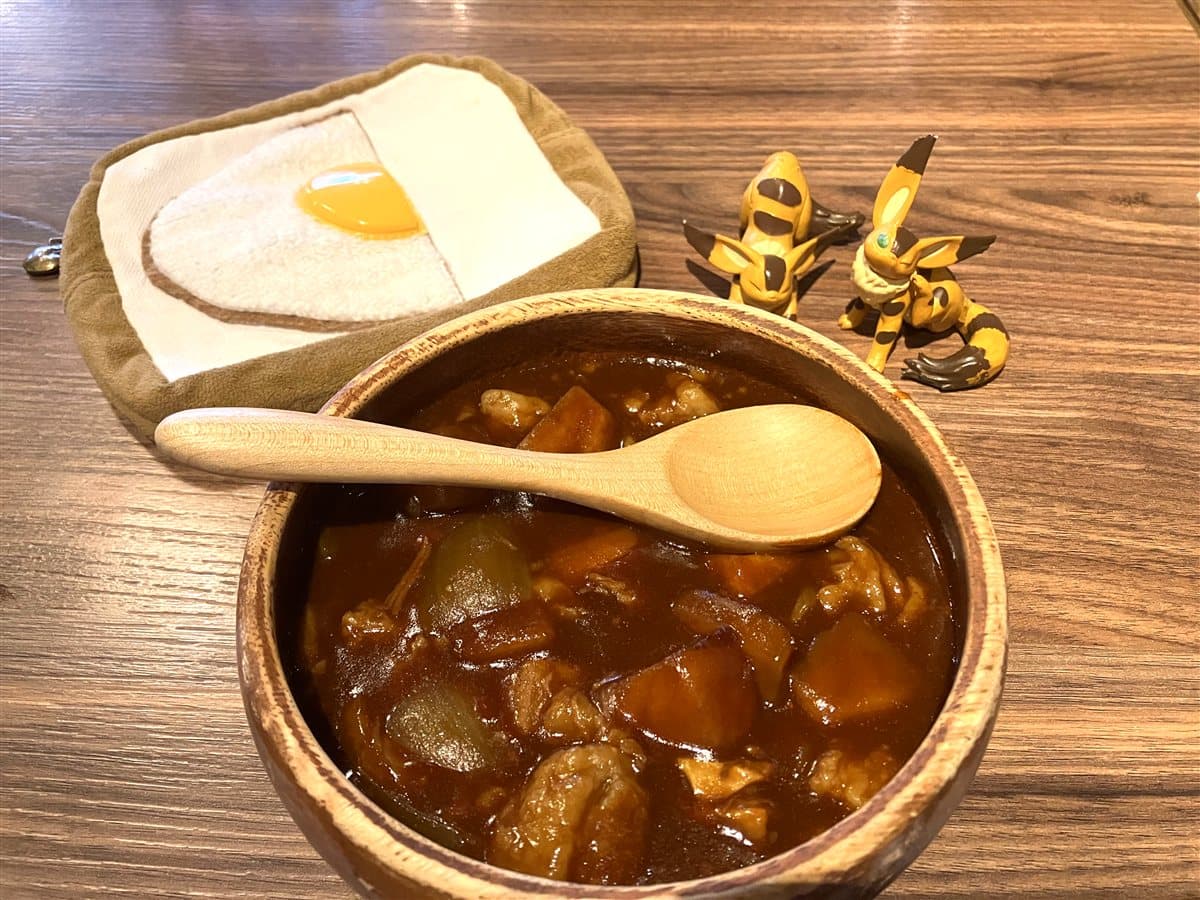 木の器に入ったビーフシチューと目玉焼きトーストのポーチ