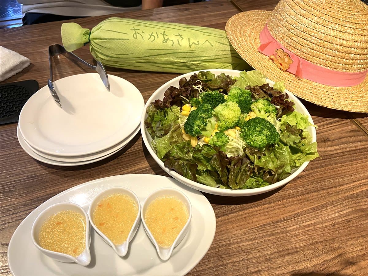 サツキの麦わら帽子と「おかあさんへ」のとうもろこしが添えられたサラダとスープ