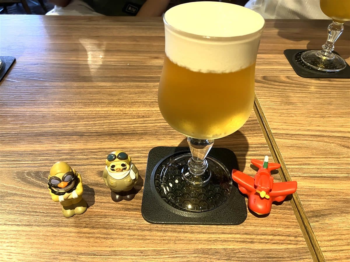 ポルコと飛行艇のフィギュアが添えられたバター&シナモンクリームのビール風モクテル(ノンアルコール)