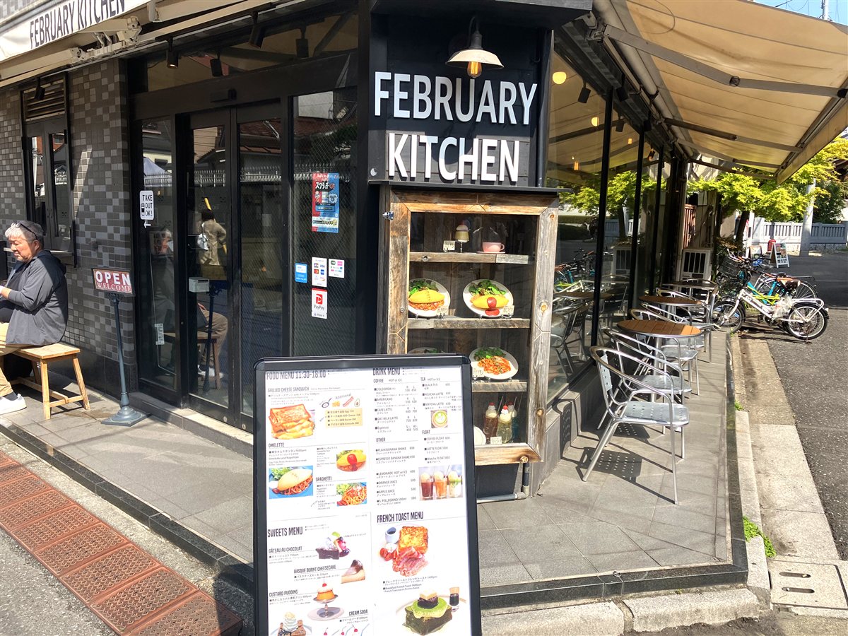 FEBRUARY KITCHENの外観。角地のガラス張りの店構えとメニュー看板