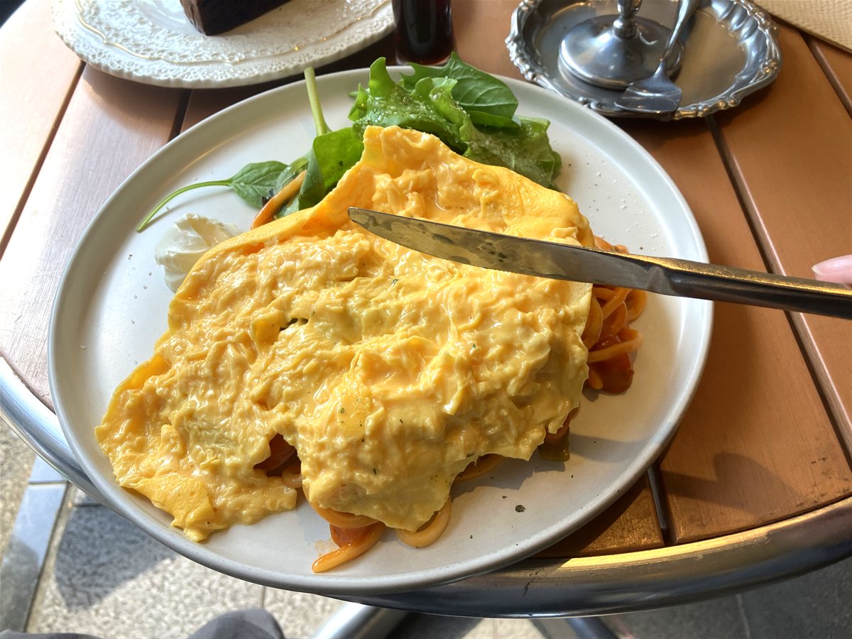 ナイフで開いた東京オムナポリタン。とろとろの卵が太麺ナポリタンを覆っている