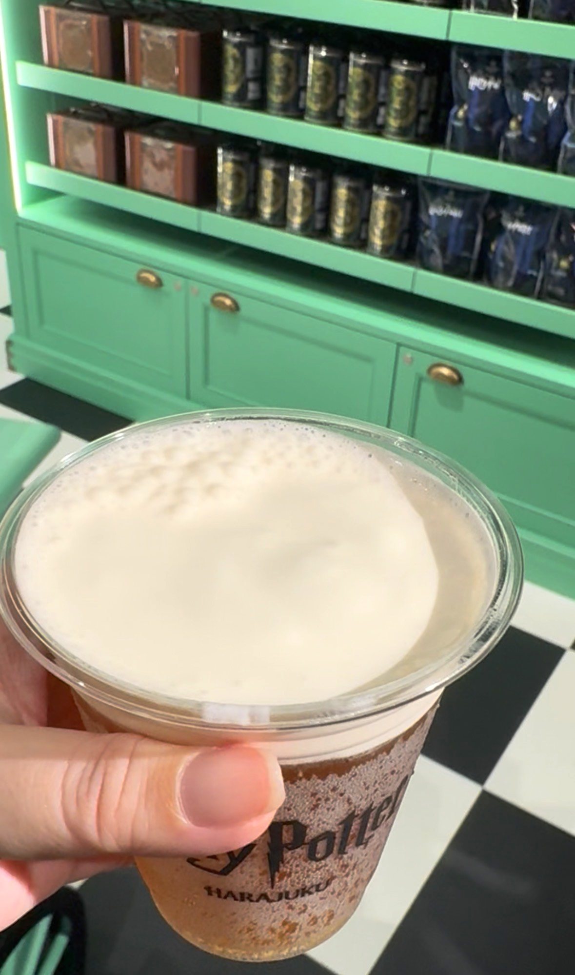 手に持ったバタービール。白い泡がもこもこと盛り上がっている