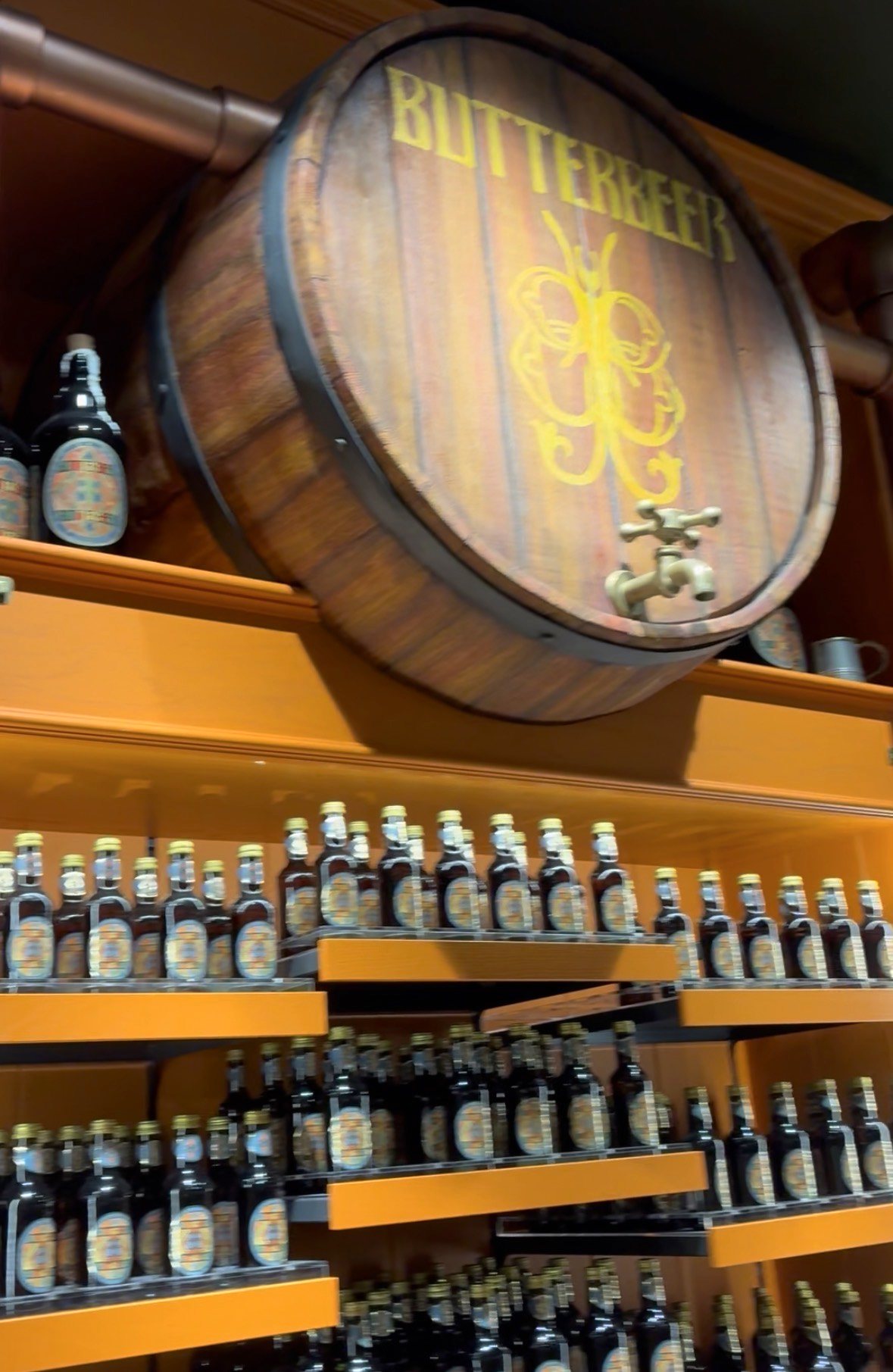 BUTTERBEERの樽と瓶入りバタービールがずらりと並ぶ棚