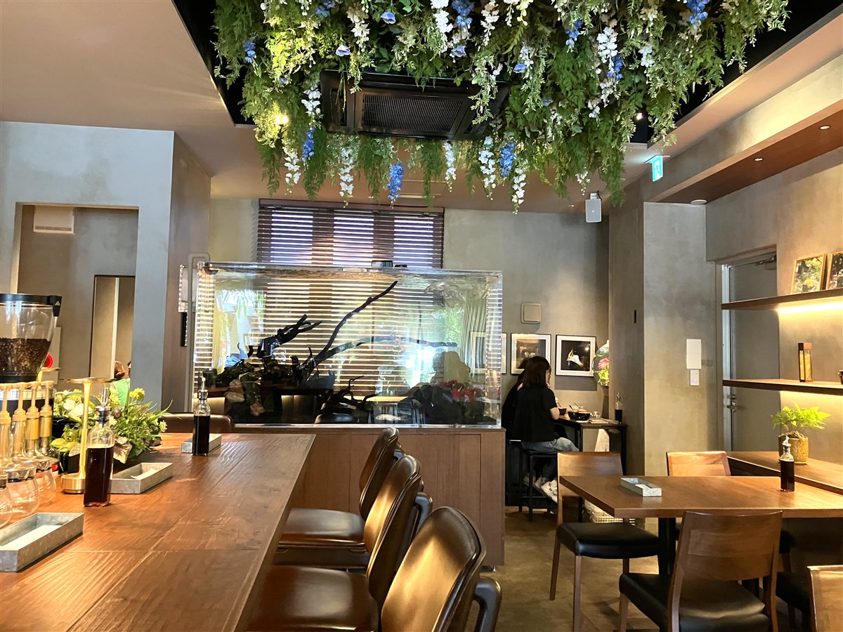 i2 cafe店内。天井から吊るされた花のシャンデリアと大きな水槽