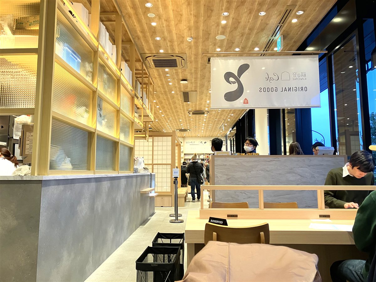 棋の音Cafeの店内。明るい木目の天井とオリジナルグッズの売り場