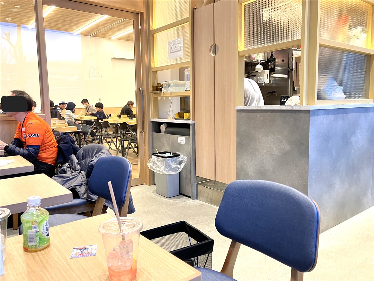 棋の音Cafeの座席。木のテーブルと青い椅子