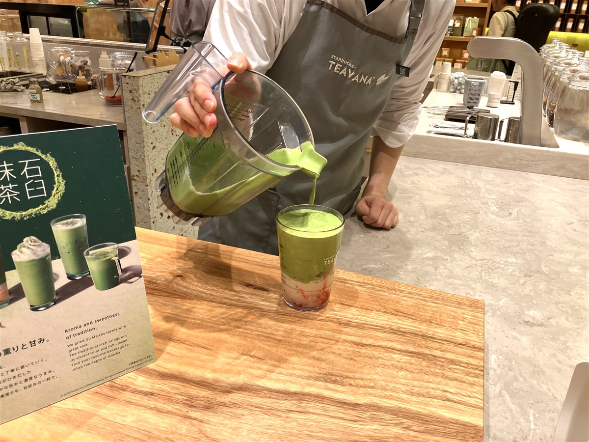 TEAVANAのエプロンを着けたバリスタが石臼抹茶ドリンクを注ぐ様子