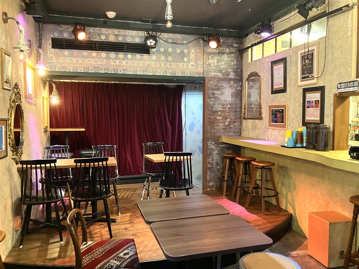 赤い緞帳のステージがある奥の部屋。ウッドチェアとカウンター席