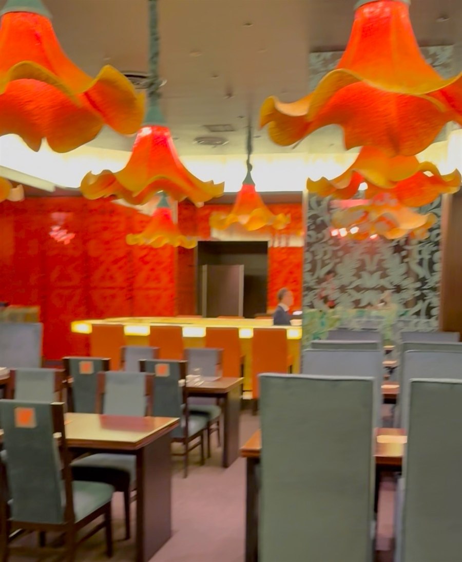 レストラン「カンナ」の店内。カンナの花をモチーフにしたオレンジ色のランプが天井から連なる