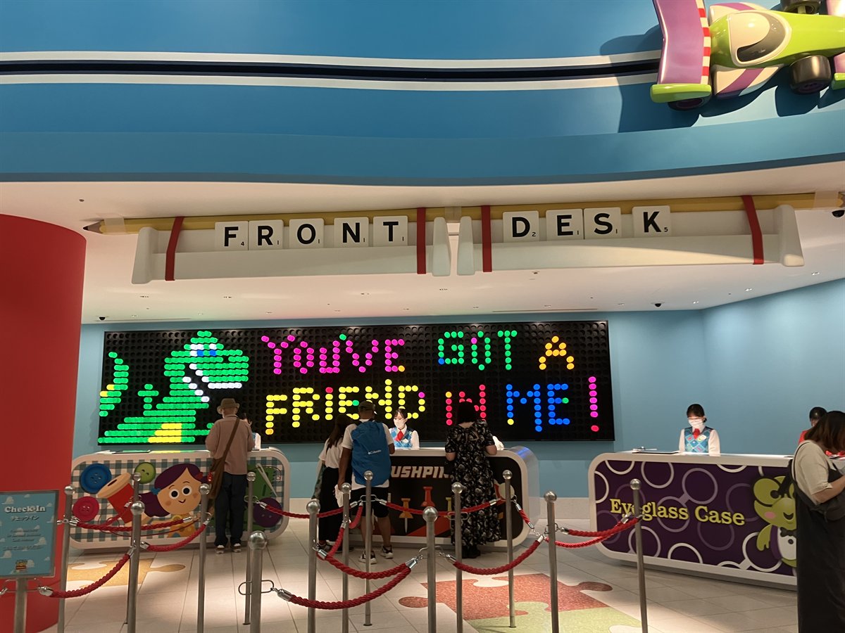 トイストーリーホテルのフロントデスク。スクラブルの文字とライトブライトのYOUVE GOT A FRIEND IN MEのサイン